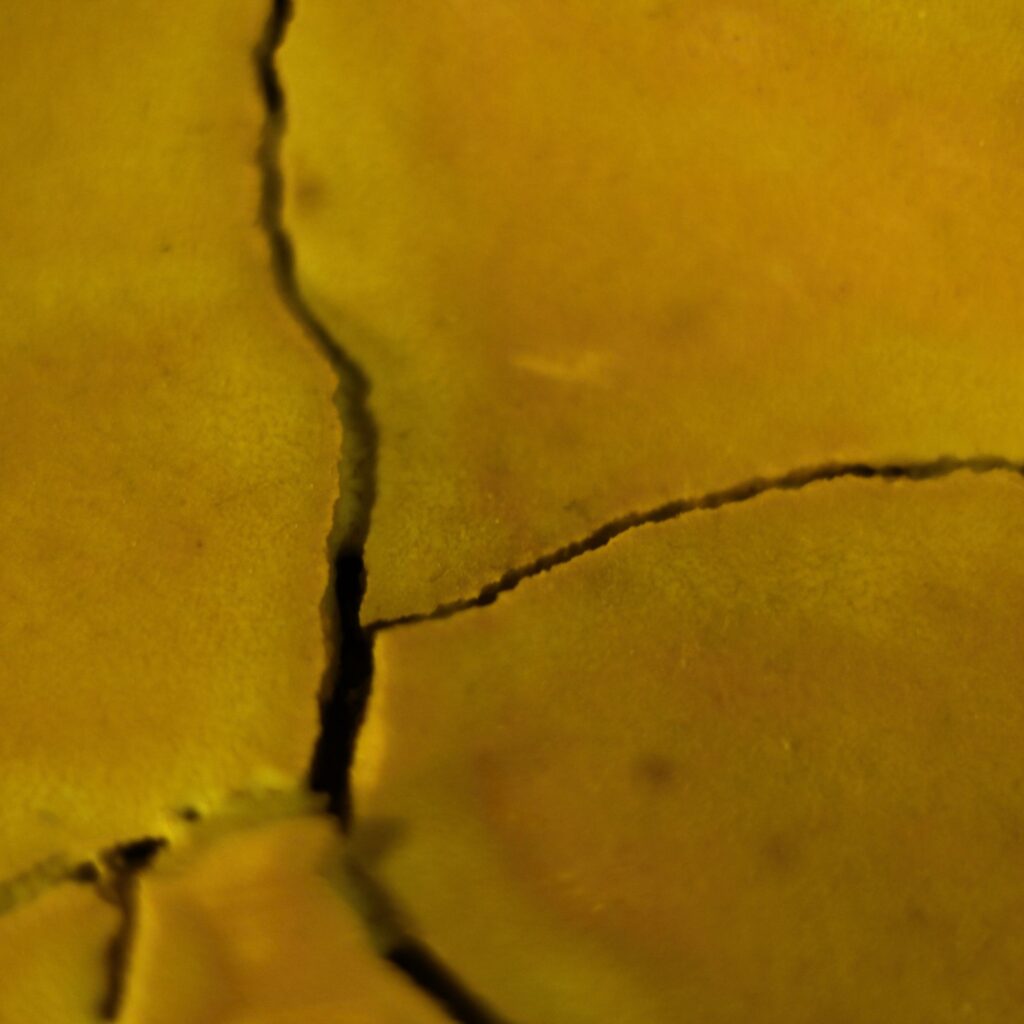 eine gelbe Landschaft mit tiefen schwarzen Rissen
