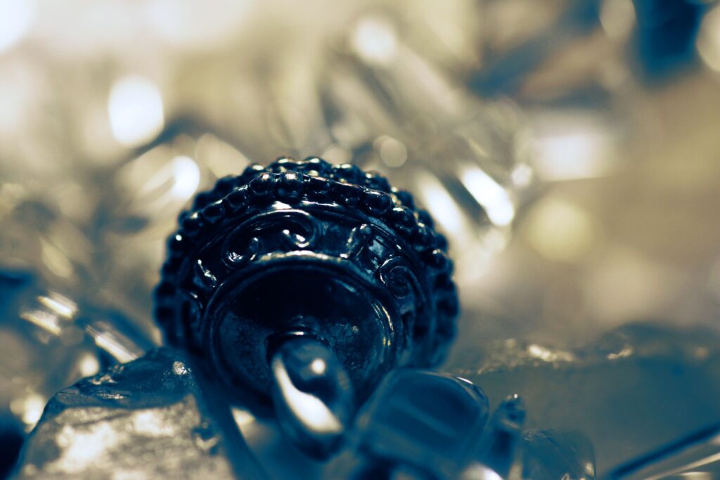 Abstrakte Makroaufnahme einer Metallperle mit hellem Bokeh.